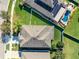 Birds eye view of a home with a dark roof and green lawn with a neighborhood pool visible at 11525 Scarlet Ibis Pl, Riverview, FL 33569