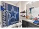Bathroom with granite countertops, black cabinets, and Cowboys themed shower curtain at 11525 Scarlet Ibis Pl, Riverview, FL 33569