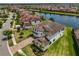Stunning aerial view of a luxurious home with tile roof, manicured lawn, and beautiful landscaping near a lake at 11909 Climbing Fern Ave, Riverview, FL 33579