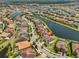 Panoramic aerial view of a residential community with a lake, showcasing lush landscaping, tile roofs, and water views at 11909 Climbing Fern Ave, Riverview, FL 33579