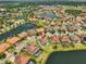 Grand aerial view of a well-planned residential community featuring lush landscaping, tile roofs, and serene waterways at 11909 Climbing Fern Ave, Riverview, FL 33579