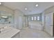 Bright bathroom featuring a tub, shower, and dual sink vanity at 11909 Climbing Fern Ave, Riverview, FL 33579