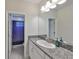 Bathroom featuring granite countertop vanity, sink, and framed mirror, plus walk-in shower at 11909 Climbing Fern Ave, Riverview, FL 33579