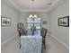 Elegant dining room with a tray ceiling, chandelier, and a large wooden table with upholstered chairs at 11909 Climbing Fern Ave, Riverview, FL 33579