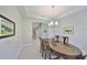Elegant dining room with a large wooden table, chandelier, and neutral-colored walls, steps away from the staircase at 11909 Climbing Fern Ave, Riverview, FL 33579
