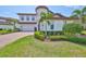 Beautifully landscaped front yard with lush green grass, palm trees, and decorative shrubs enhancing curb appeal at 11909 Climbing Fern Ave, Riverview, FL 33579