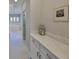 Hallway with access to bathroom; features art and decorative jar at 11909 Climbing Fern Ave, Riverview, FL 33579