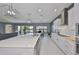 Open concept kitchen with stainless steel appliances and large island, flowing into the living area at 11909 Climbing Fern Ave, Riverview, FL 33579