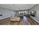 Open living room boasts wood floors, neutral walls, comfortable seating, and lake views through large windows at 11909 Climbing Fern Ave, Riverview, FL 33579