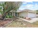 Inviting home featuring a well-kept lawn, charming stone details, and an attached two-car garage at 1227 Tuxford Dr, Brandon, FL 33511