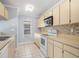 Kitchen featuring light cabinets, tile backsplash, and stainless steel microwave at 1227 Tuxford Dr, Brandon, FL 33511