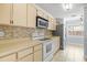Kitchen with light cabinets, tiled backsplash, stainless steel fridge and electric range at 1227 Tuxford Dr, Brandon, FL 33511