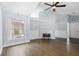 Open-concept living room with vaulted ceiling, wood floors, fireplace, and natural light from the windows at 1227 Tuxford Dr, Brandon, FL 33511
