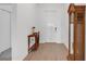 Bright foyer with wood-look tile floors, white walls, and a decorative table and grandfather clock at 12572 Bergstrom Bay Dr, Riverview, FL 33579