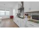Bright kitchen with stainless steel appliances and white cabinets next to a dining room and expansive windows at 12572 Bergstrom Bay Dr, Riverview, FL 33579