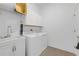 Neat laundry area with white washer, dryer, sink and overhead storage for organized living at 12572 Bergstrom Bay Dr, Riverview, FL 33579
