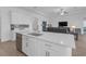 Open-concept floor plan integrates kitchen and living area with stainless steel appliances and wood-style floors at 12572 Bergstrom Bay Dr, Riverview, FL 33579