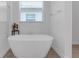Bright bathroom with a standalone soaking tub and a glass-enclosed shower at 12572 Bergstrom Bay Dr, Riverview, FL 33579