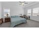 Spacious main bedroom with large windows, tray ceiling, fan, and an ensuite bathroom at 12572 Bergstrom Bay Dr, Riverview, FL 33579