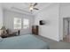 Spacious main bedroom with large windows, a tray ceiling, fan, and an ensuite bathroom at 12572 Bergstrom Bay Dr, Riverview, FL 33579