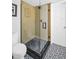 Modern shower with glass doors and striking black and white tile flooring at 12965 Ridge Rd, Largo, FL 33778