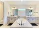 Luxurious bathroom with dual vanities, soaking tub, sleek black fixtures, and recessed lighting at 13071 Willow Grove Dr, Riverview, FL 33579