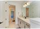 Bathroom with white cabinets, quartz countertop, modern fixtures, and a view into the adjacent room at 13071 Willow Grove Dr, Riverview, FL 33579