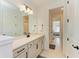 Bright bathroom featuring a large mirror, vanity with modern fixtures, and a view into the adjacent room at 13071 Willow Grove Dr, Riverview, FL 33579