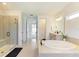 Spa-like bathroom featuring a glass shower, soaking tub, and elegant tile flooring at 13071 Willow Grove Dr, Riverview, FL 33579