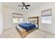 Bedroom with windows, neutral walls, modern ceiling fan and a bed with blue covers to create a cozy space at 13071 Willow Grove Dr, Riverview, FL 33579