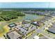 Aerial view of community amenities including a pool, clubhouse, playground, and tennis courts, all surrounded by a scenic lake at 13071 Willow Grove Dr, Riverview, FL 33579