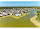 Aerial view of community amenities including a pool, clubhouse, playground, and tennis courts, all surrounded by a scenic lake at 13071 Willow Grove Dr, Riverview, FL 33579