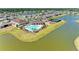 Aerial view of community amenities including a pool, clubhouse, playground, and tennis courts, all surrounded by a scenic lake at 13071 Willow Grove Dr, Riverview, FL 33579