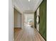 Hallway with light wood floors, modern decor, and a round mirror on an accent wall at 13071 Willow Grove Dr, Riverview, FL 33579