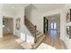 Spacious entryway with staircase, wood floors, and modern decor leading to an accent wall with a mirror at 13071 Willow Grove Dr, Riverview, FL 33579