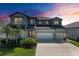 Two-story home showcasing lush landscaping, well-manicured lawn, and a three-car garage at 13071 Willow Grove Dr, Riverview, FL 33579