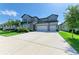 Two-story home with a long driveway leading to a three-car garage at 13071 Willow Grove Dr, Riverview, FL 33579