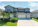 Two-story home showcasing lush landscaping, well-manicured lawn, and a three-car garage at 13071 Willow Grove Dr, Riverview, FL 33579