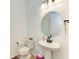 Bright powder room featuring a pedestal sink, round mirror, and modern fixtures at 13071 Willow Grove Dr, Riverview, FL 33579