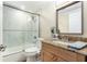 Bright bathroom features a granite-topped vanity and tub-shower combo with white marble-look tile at 13401 Neptune Dr, Hudson, FL 34667