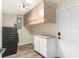 Functional laundry area featuring wood-look tile flooring, ample cabinet space, and a modern washer at 13401 Neptune Dr, Hudson, FL 34667