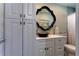 This bathroom features white cabinets, a unique bowl sink, and a decorative mirror above the sink at 1430 Normandy Park Oaks Dr # 9, Clearwater, FL 33756