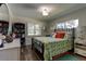 Bright bedroom with hardwood floors, a black metal bed frame, and ample natural light at 1430 Normandy Park Oaks Dr # 9, Clearwater, FL 33756