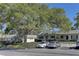 View of the property showing the home's facade with a large tree in the front and parking spaces nearby at 1430 Normandy Park Oaks Dr # 9, Clearwater, FL 33756