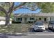 Charming home featuring green shutters, a well-manicured lawn, and a driveway with parking spaces at 1430 Normandy Park Oaks Dr # 9, Clearwater, FL 33756