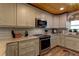 Bright kitchen featuring stainless steel appliances, gray cabinets, and granite countertops at 1430 Normandy Park Oaks Dr # 9, Clearwater, FL 33756
