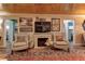 Charming living room with a fireplace, wood plank ceiling, and two comfortable armchairs at 1430 Normandy Park Oaks Dr # 9, Clearwater, FL 33756