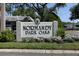 Welcoming 'Normandy Park Oaks' sign with beautiful landscaping enhancing curb appeal at 1430 Normandy Park Oaks Dr # 9, Clearwater, FL 33756