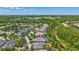 Aerial view of a home with a screened-in pool, surrounded by lush greenery in a suburban neighborhood at 14727 Tudor Chase Dr, Tampa, FL 33626