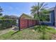 Fenced backyard featuring a mature palm tree and well-maintained lawn, offering privacy and charm at 14727 Tudor Chase Dr, Tampa, FL 33626